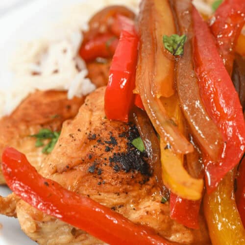 A chicken breast topped with peppers.
