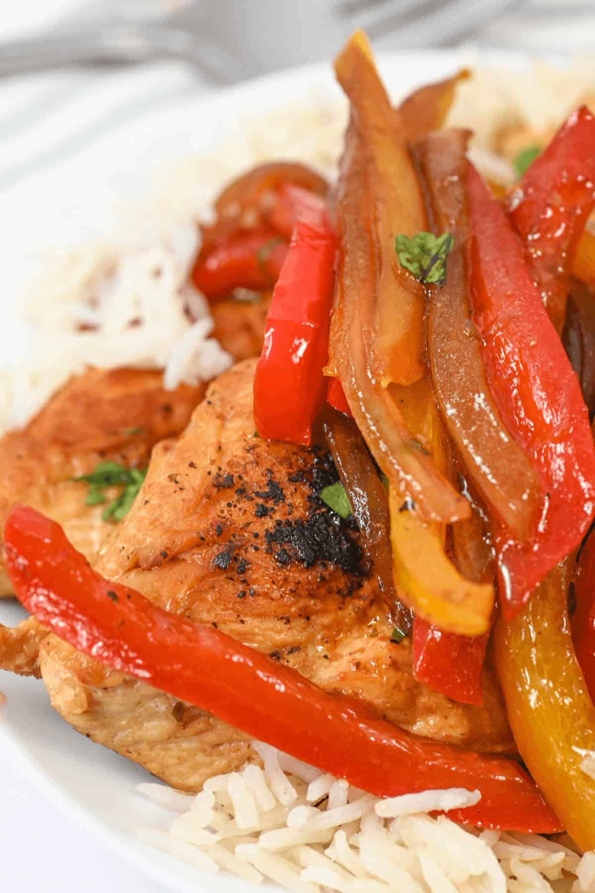A chicken breast topped with peppers.