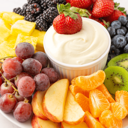 A colorful selection of fresh fruits with a bowl of marshmallow fluff fruit dip.