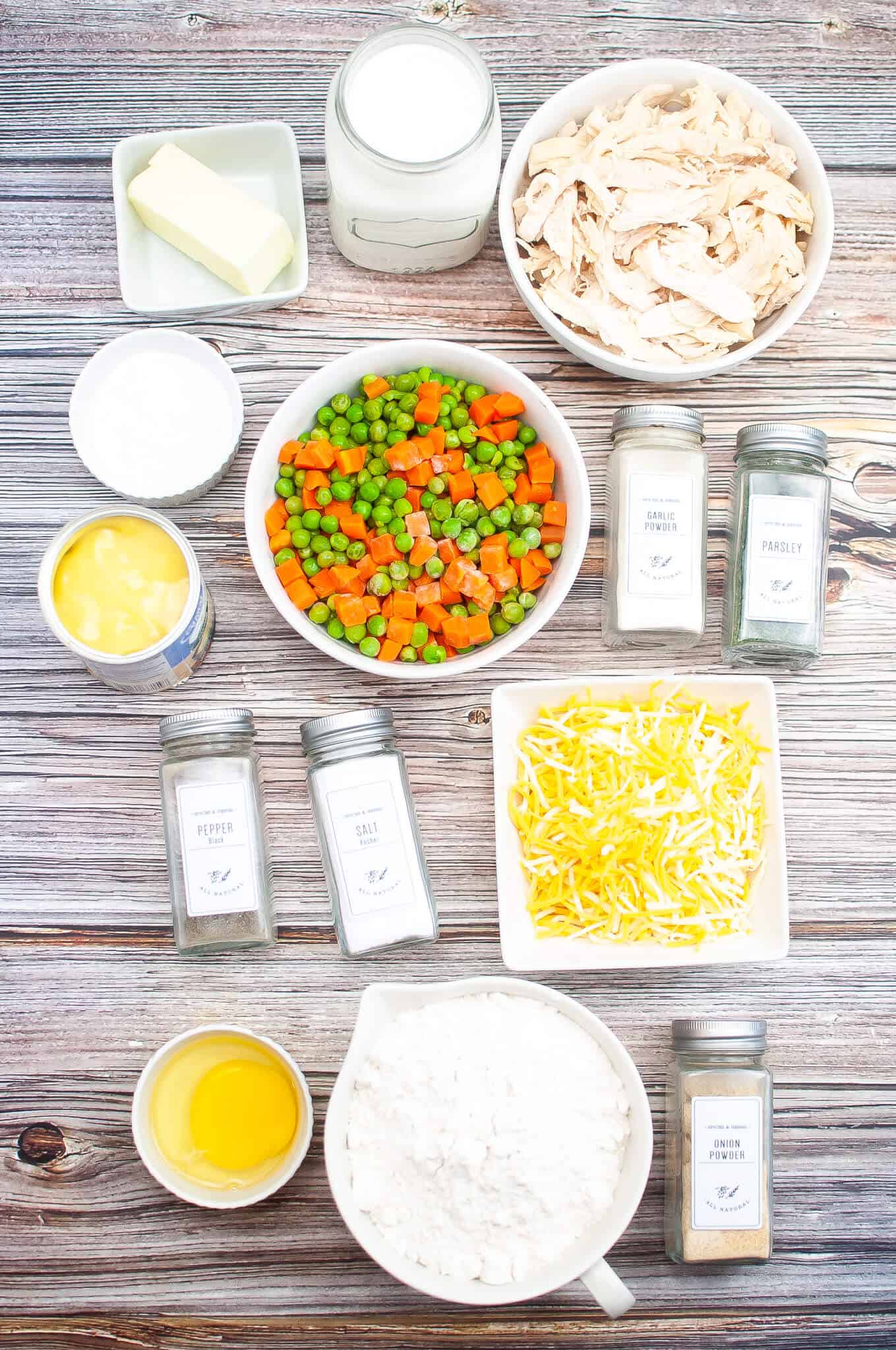 The ingredients for the dish are laid out on a wooden table.