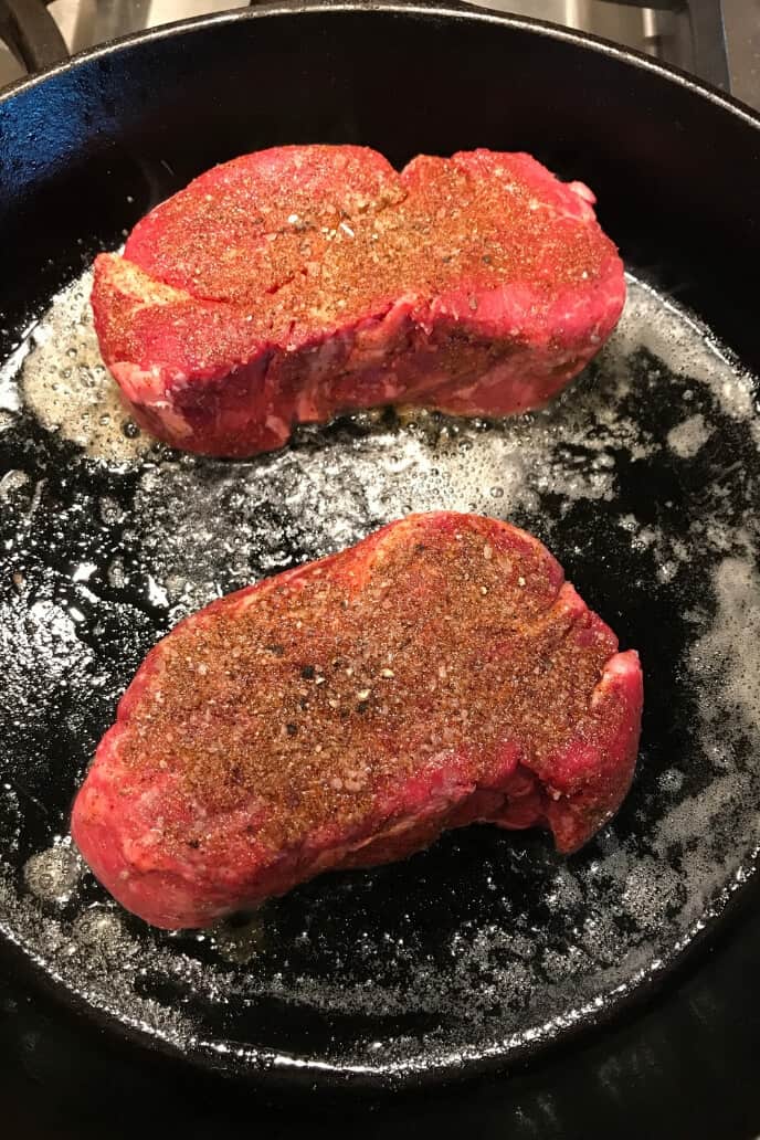 2 Steaks in a cast iron skillet. 