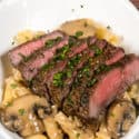 Filet Mignon in Sherry Mushroom Cream Sauce in a white bowl with a fork