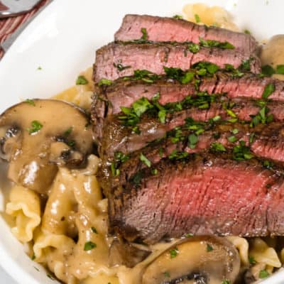 Filet Mignon in Sherry Mushroom Cream Sauce in a white bowl with a fork