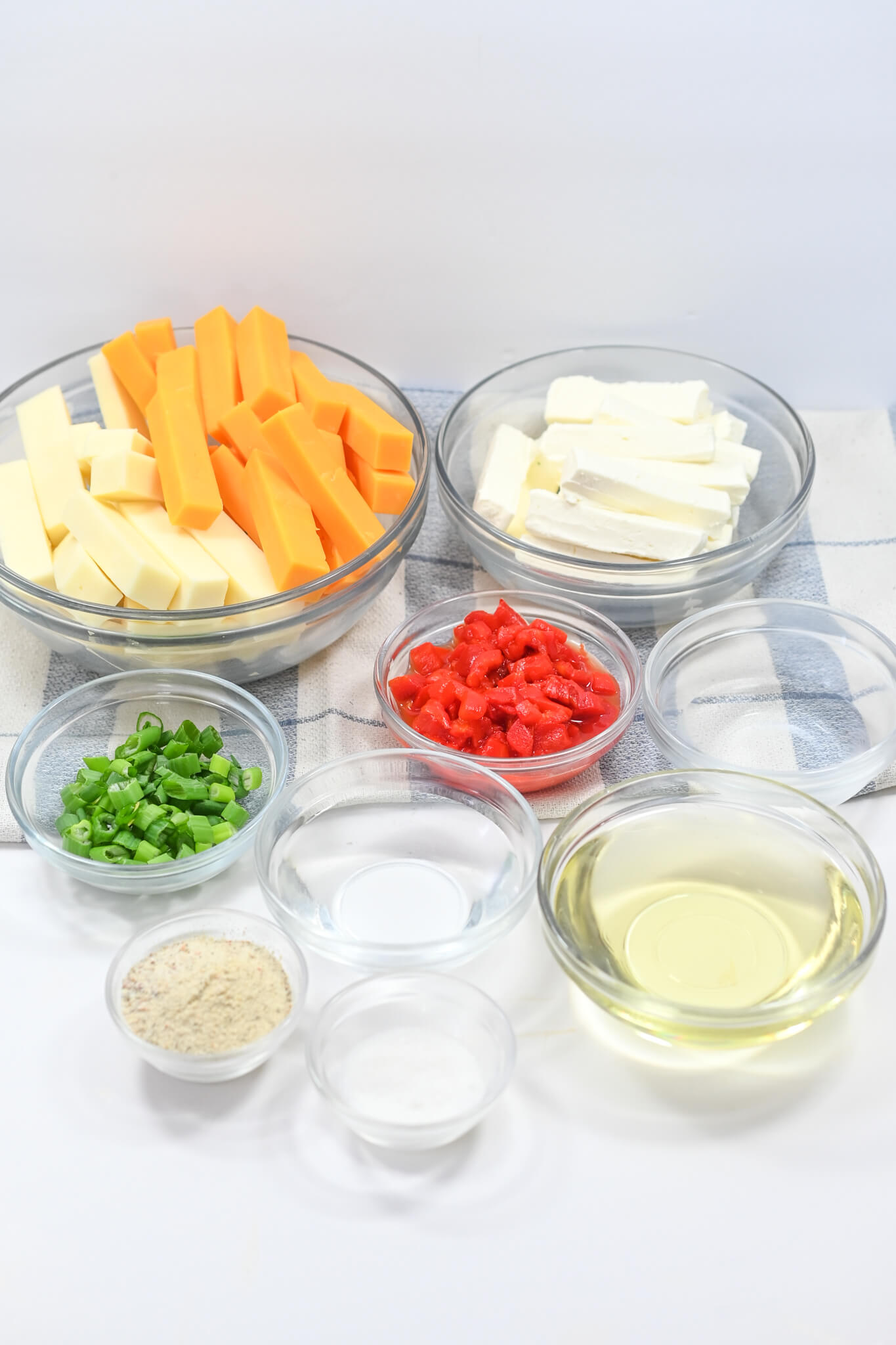 Various bowls of  cheese ingredients and vegetables for the dish.
