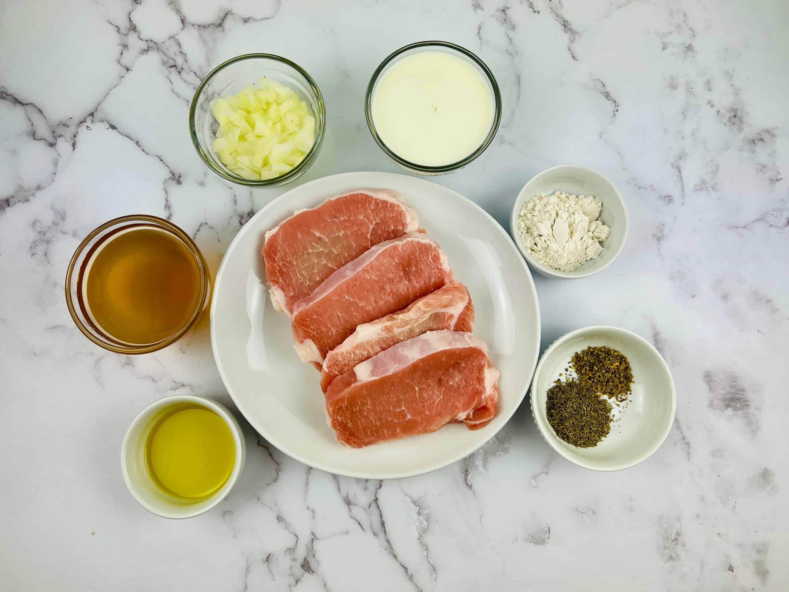 Pan seared pork chops served on a white plate.