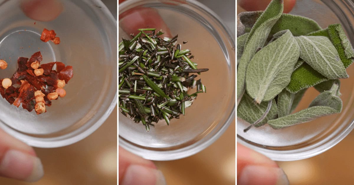 Close-up of three glass bowls containing different herbs and spices for a perfect Herbed Lemon Chicken: crushed red pepper flakes, chopped rosemary, and fresh sage leaves.
