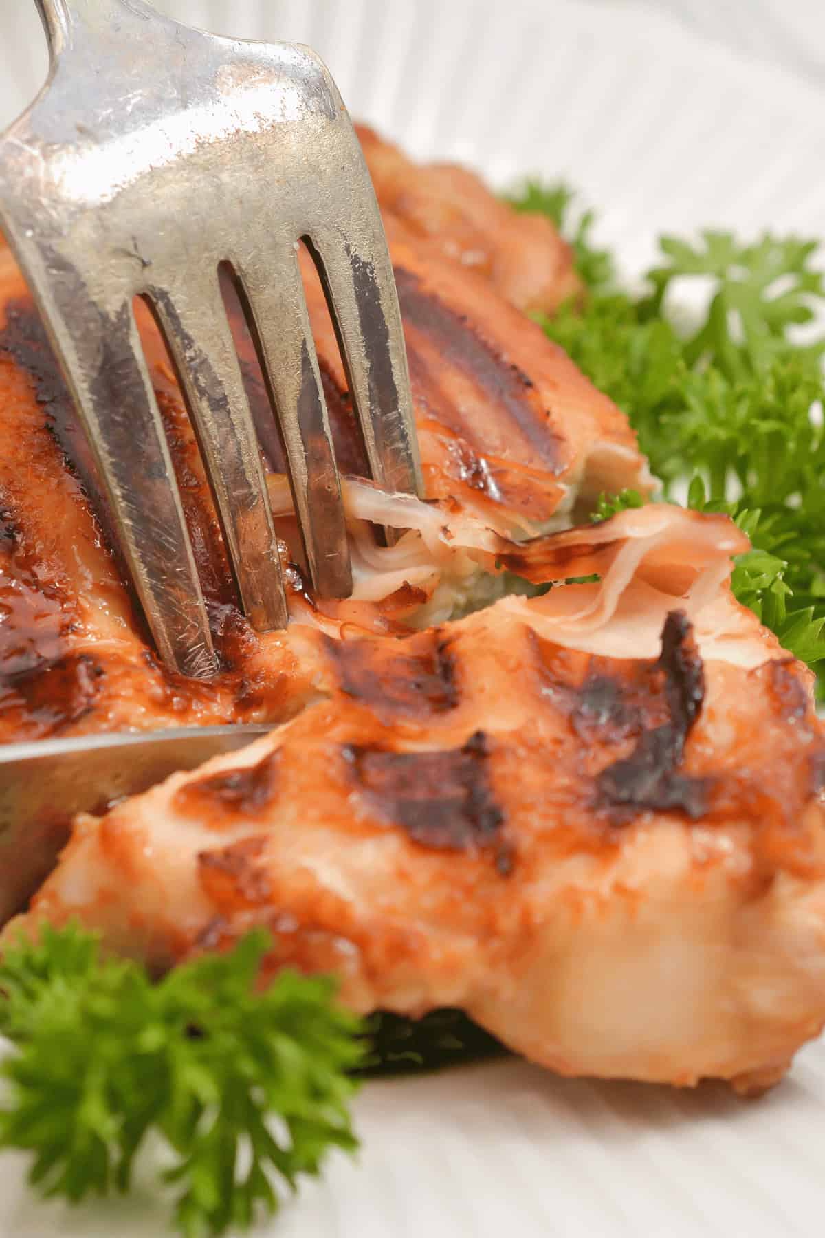 Cutting up the meal with a fork and knife.