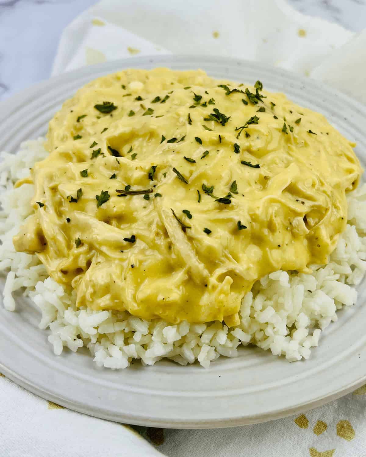 A plate of slow cooker Italian dressing chicken on a table.