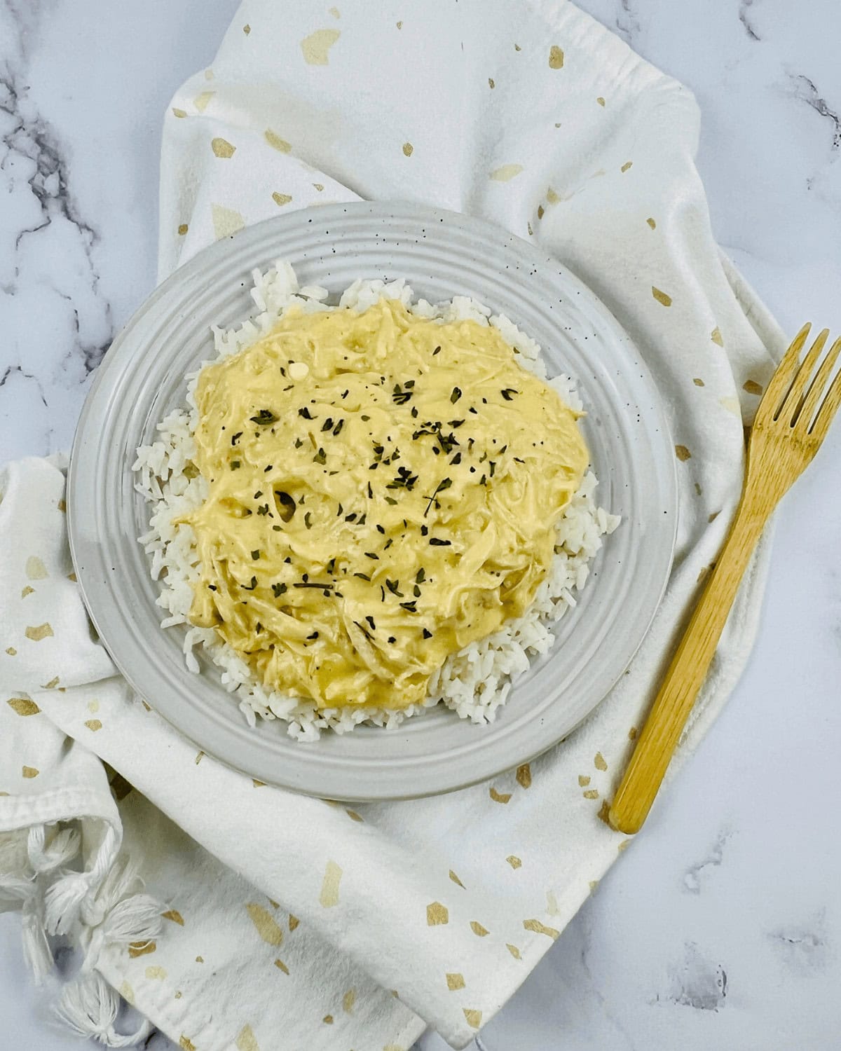 A glass bowl of the finished meal with a serving spoon beside it.