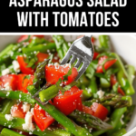 A bowl of cold tomato and asparagus salad with feta cheese, garnished with herbs, with a fork lifting some asparagus.