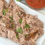 A white serving tray with the shredded meat on top.