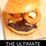 Close-up of a burger with a beef patty, cheese, onion rings, and barbecue sauce in a bun. Below is the text: "Introducing the Ultimate Rodeo Burger.