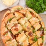 A bacon ranch pull apart bread with fresh herbs on top.
