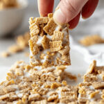 A hand holding a piece of cereal treat made with cinnamon toast crunch bars.