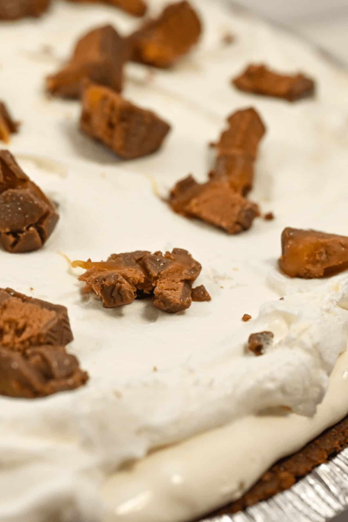 Close-up of the dessert topped with chunks of brown chocolate or candy.