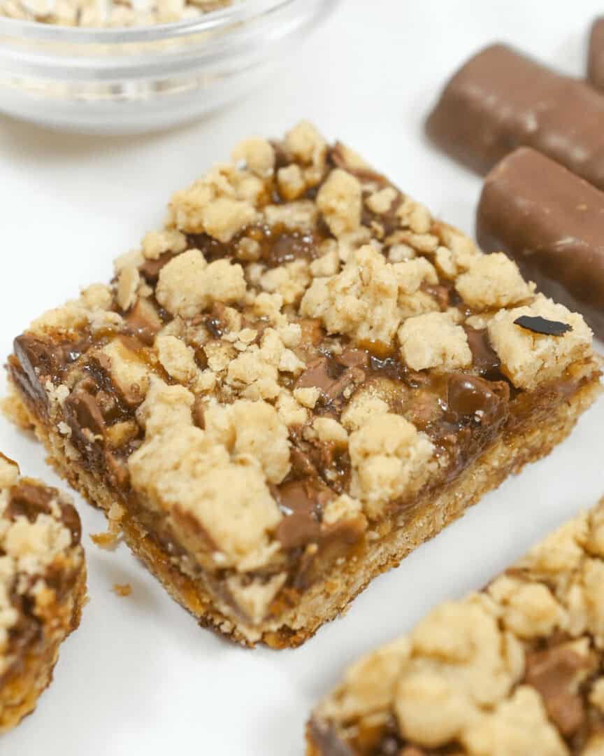 Twix oatmeal caramel bars on a white tray.