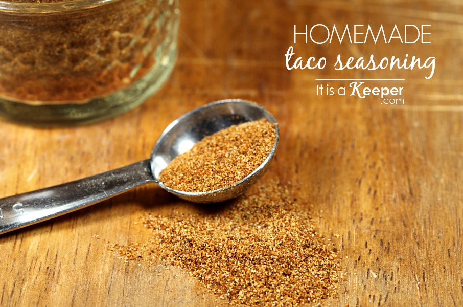 Homemade Taco Seasoning in a glass jar on a wooden table, seasoning in a tablespoon and on the table. 