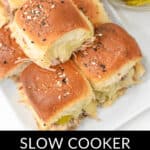 A plate of seasoned Cuban Sliders labeled "Slow Cooker Cuban Sliders," with a side dish of pickles.