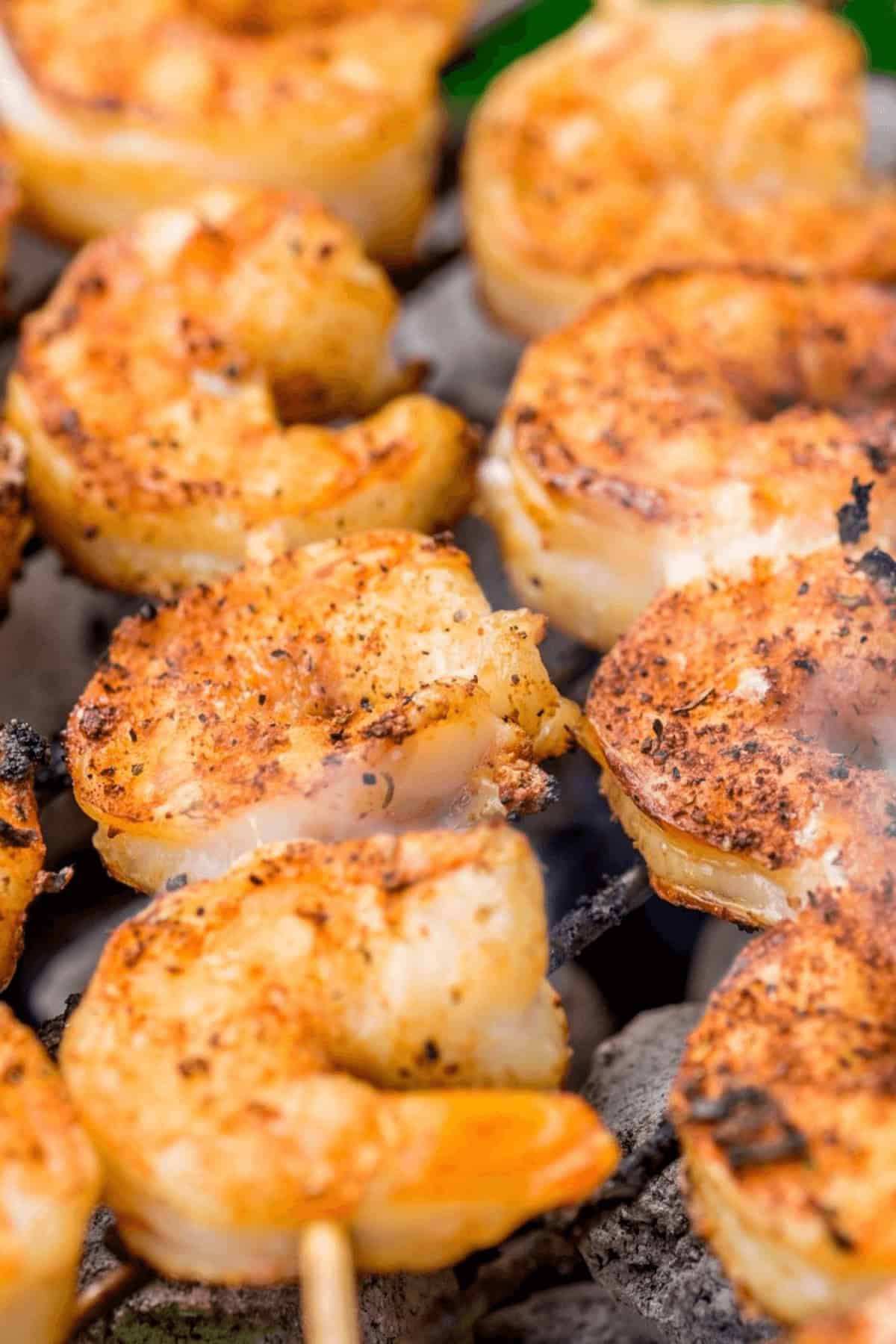 Shrimp on skwerers on a grill.