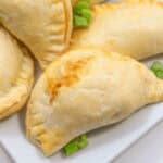 A plate of stuffed chicken empanadas on a white plate.
