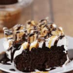 A piece of the snickers cake on a white plate.