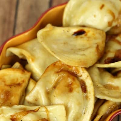 Crock pot pierogie in a yellow bowl on a wooden table