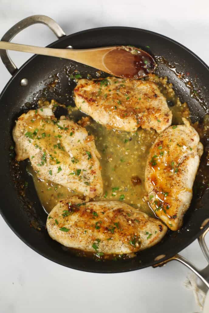 ginger chicken in a skillet with a wooden spoon