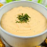 A bowl of buffalo ranch dip with celery and celery sticks.