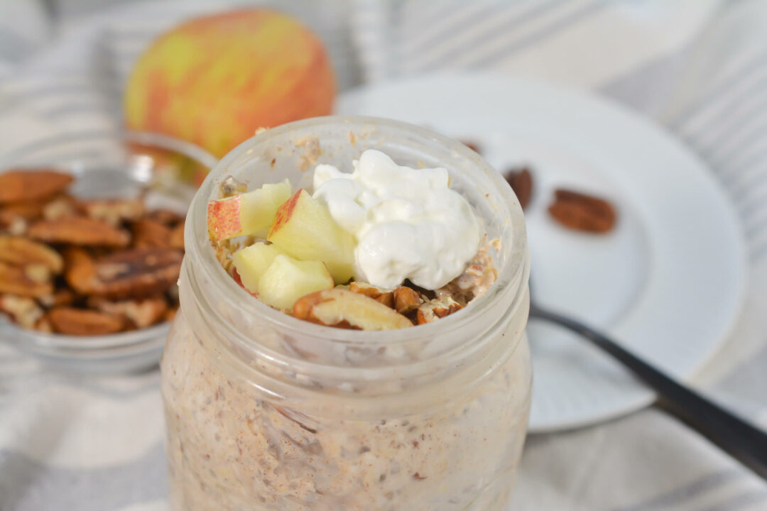 A spoon next to the mason jar of oats.