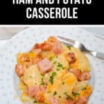 A plate of Cheesy Ham and Potato Casserole, rich and savory, is garnished with fresh parsley, with a fork on the side inviting you to indulge.