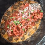 A crock pot filled with meatballs in sauce.
