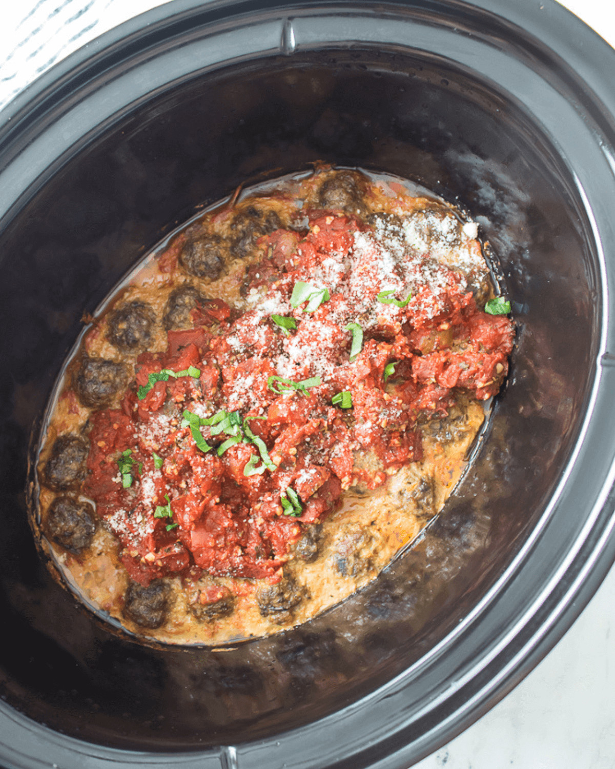 A crock pot filled with delicious meatballs and sauce.