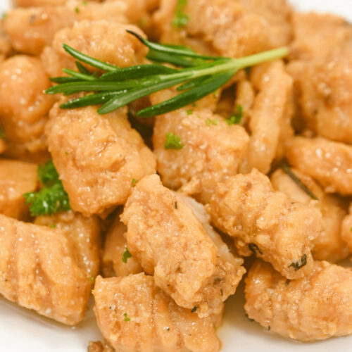 Creamy sweet potato gnocchi with a sprig of rosemary on top.