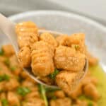 A spoon in a platter of the finished dish.