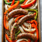 Sausage and peppers baked on a sheet.