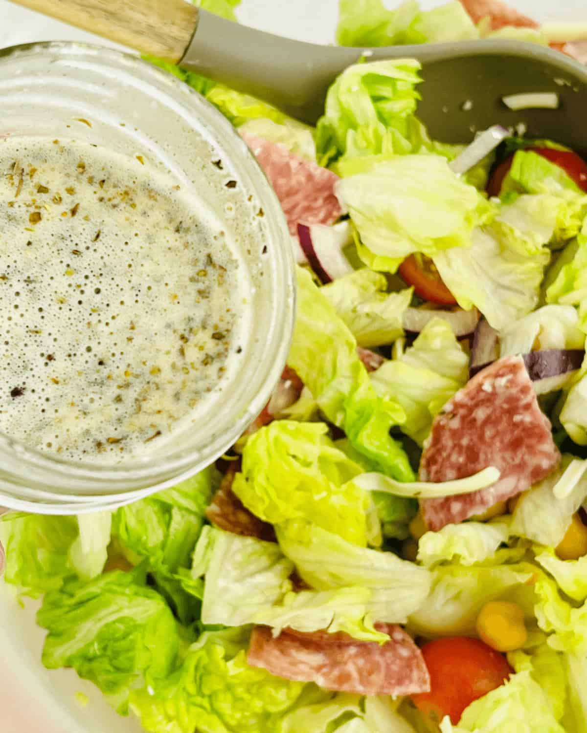 A picture of the vinaigrette being poured over the finished meal. 