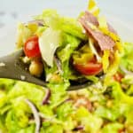 A black spoon with an Italian Chopped Salad on it.