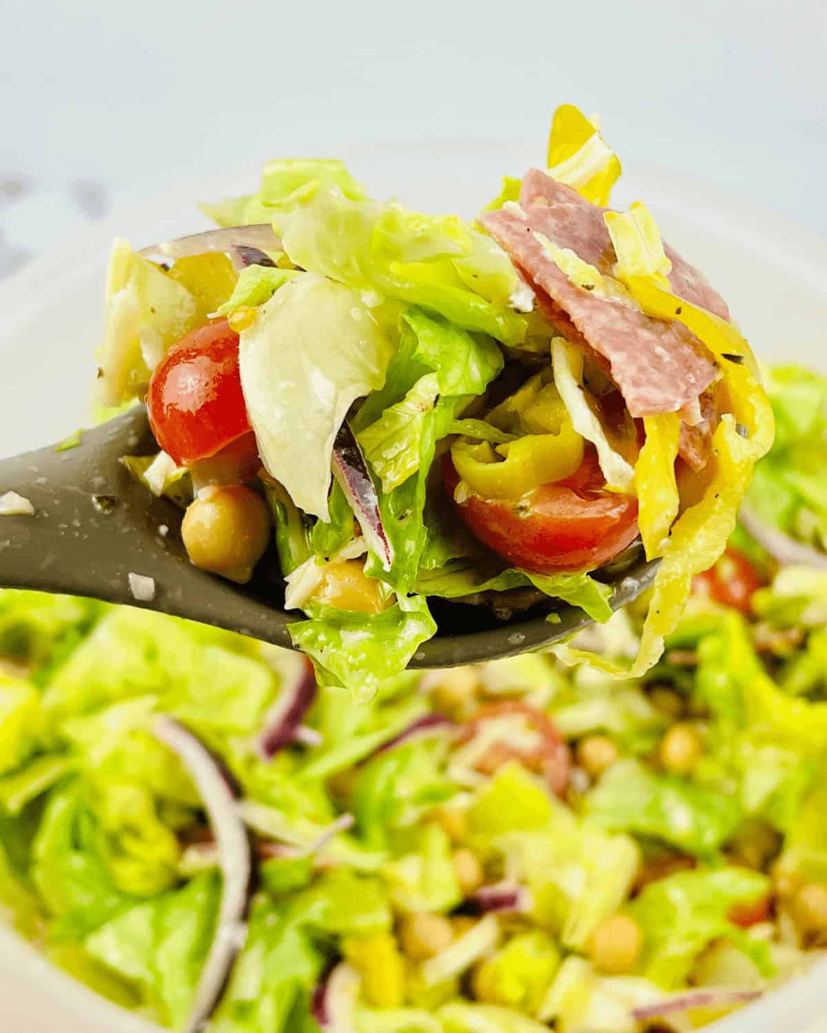 A black spoon with an Italian Chopped Salad on it.