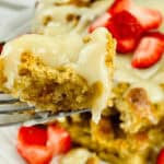 A fork lifting a bite of creamy dessert.