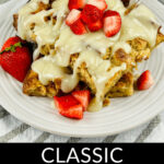 A dish of bread pudding with vanilla sauce garnished with fresh strawberries.