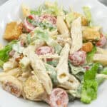 A plate of with croutons, cherry tomatoes, and mixed lettuce, served on a white plate.