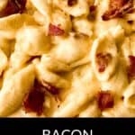 A close up of creamy Bacon Mac and Cheese, showcasing crispy bacon pieces atop rich, cheesy pasta.