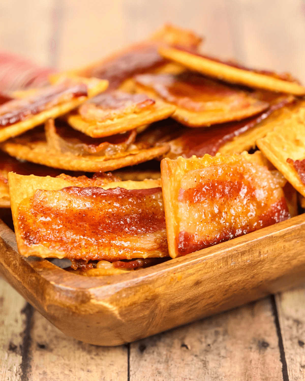 A bowl of delicious glazed bacon crackers.