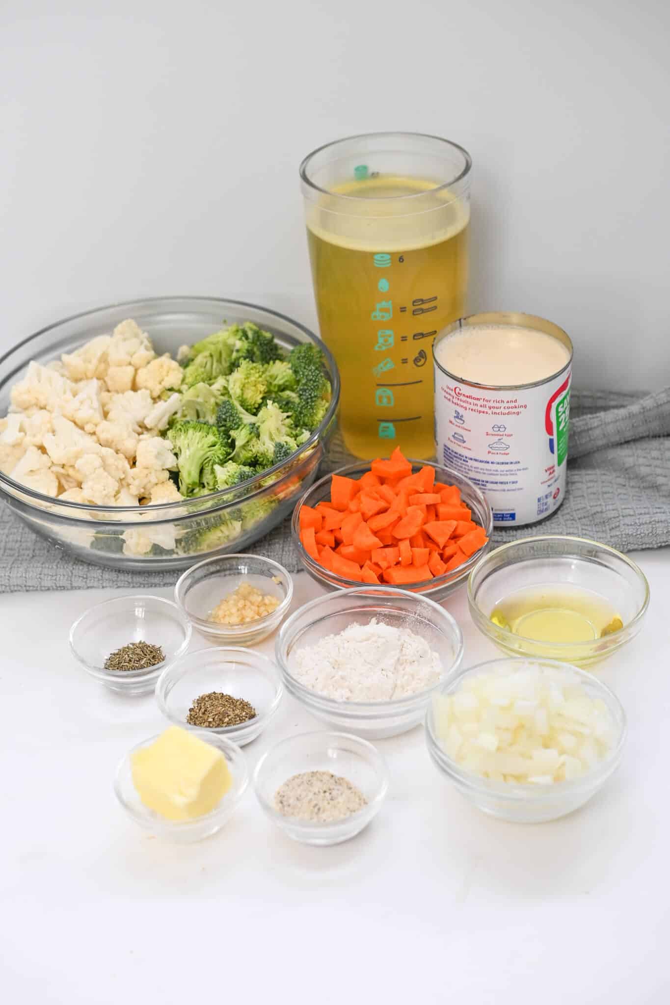 A bowl of fresh vegetables with the broth and cheese.