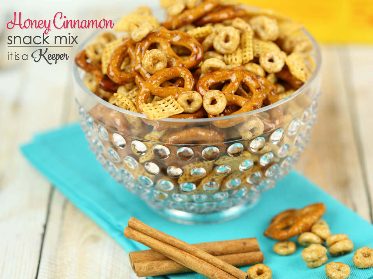 Honey Cinnamon Snack Mix in a clear bowl with a light blue napkin.