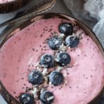 Blueberry and pineapple smoothie bowls on a grey background.