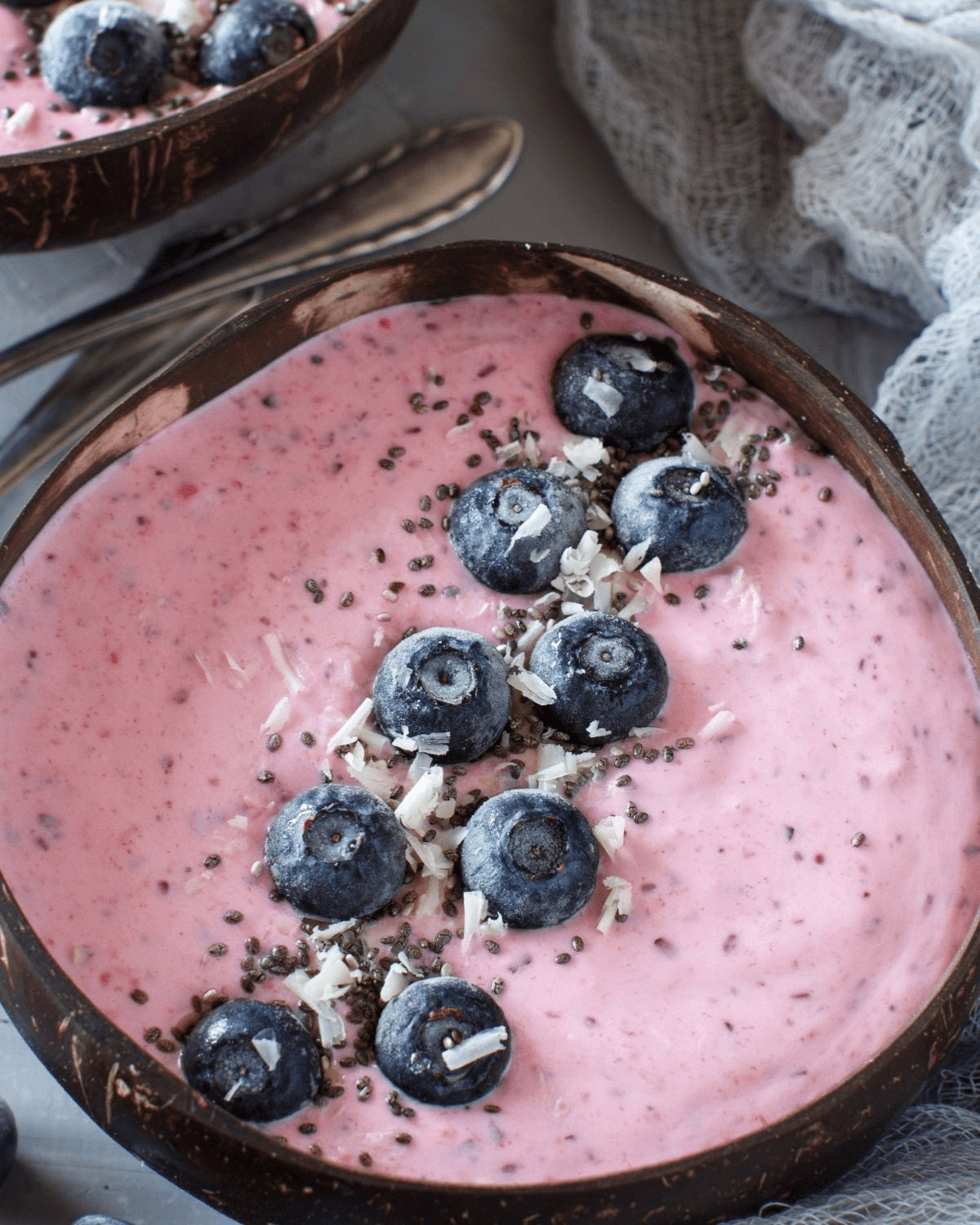 A bowl of the blueberry and pineapple smoothie with coconut on top.