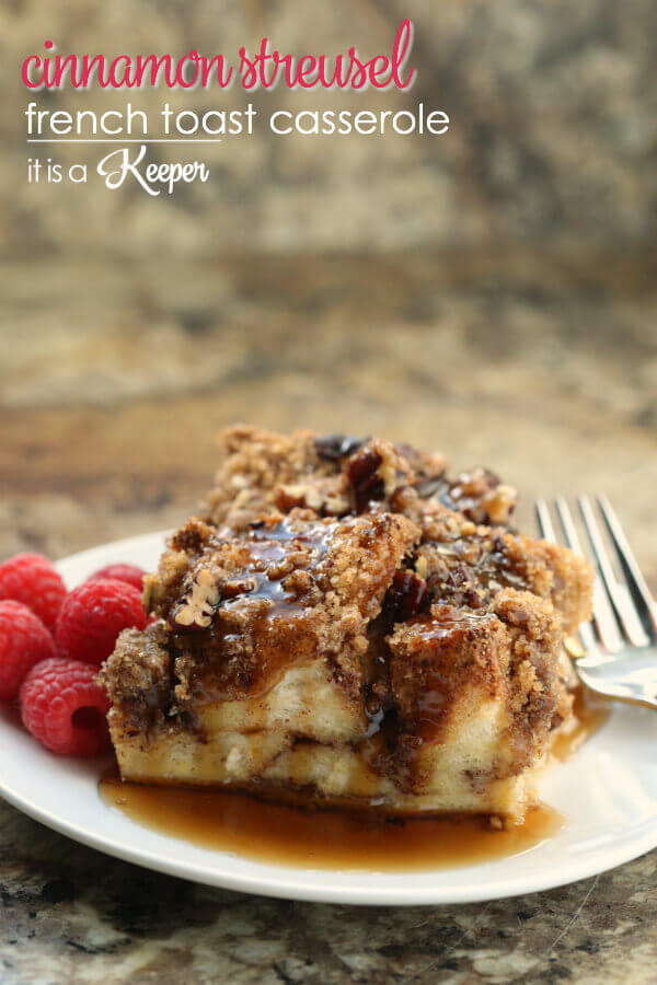 Cinnamon Streusel French Toast Casserole on white plate with raspberries and metal fork. 