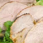 Slices of Cuban mojo pork on a white serving tray.