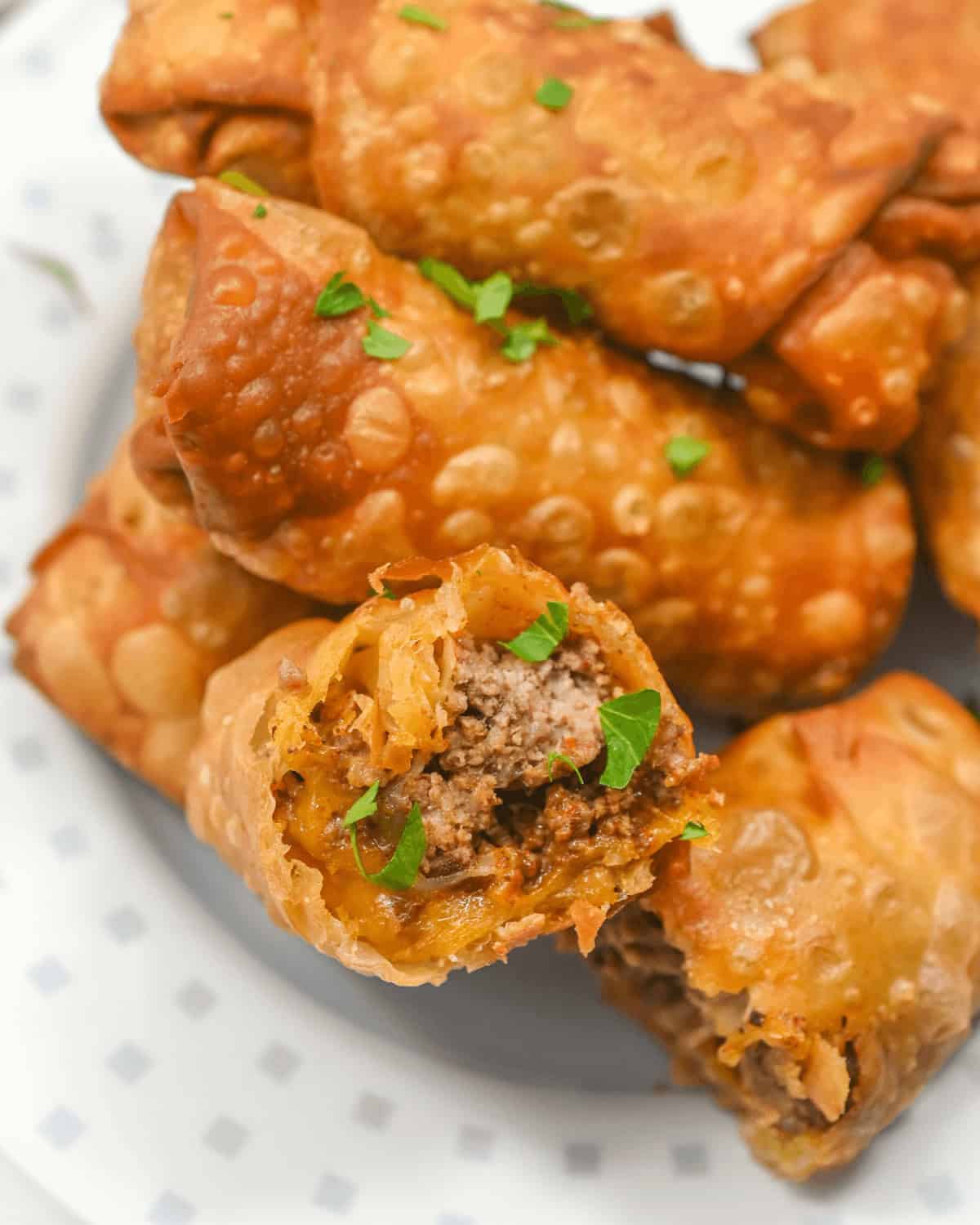 Taco Egg Rolls with meat and herbs on a plate.